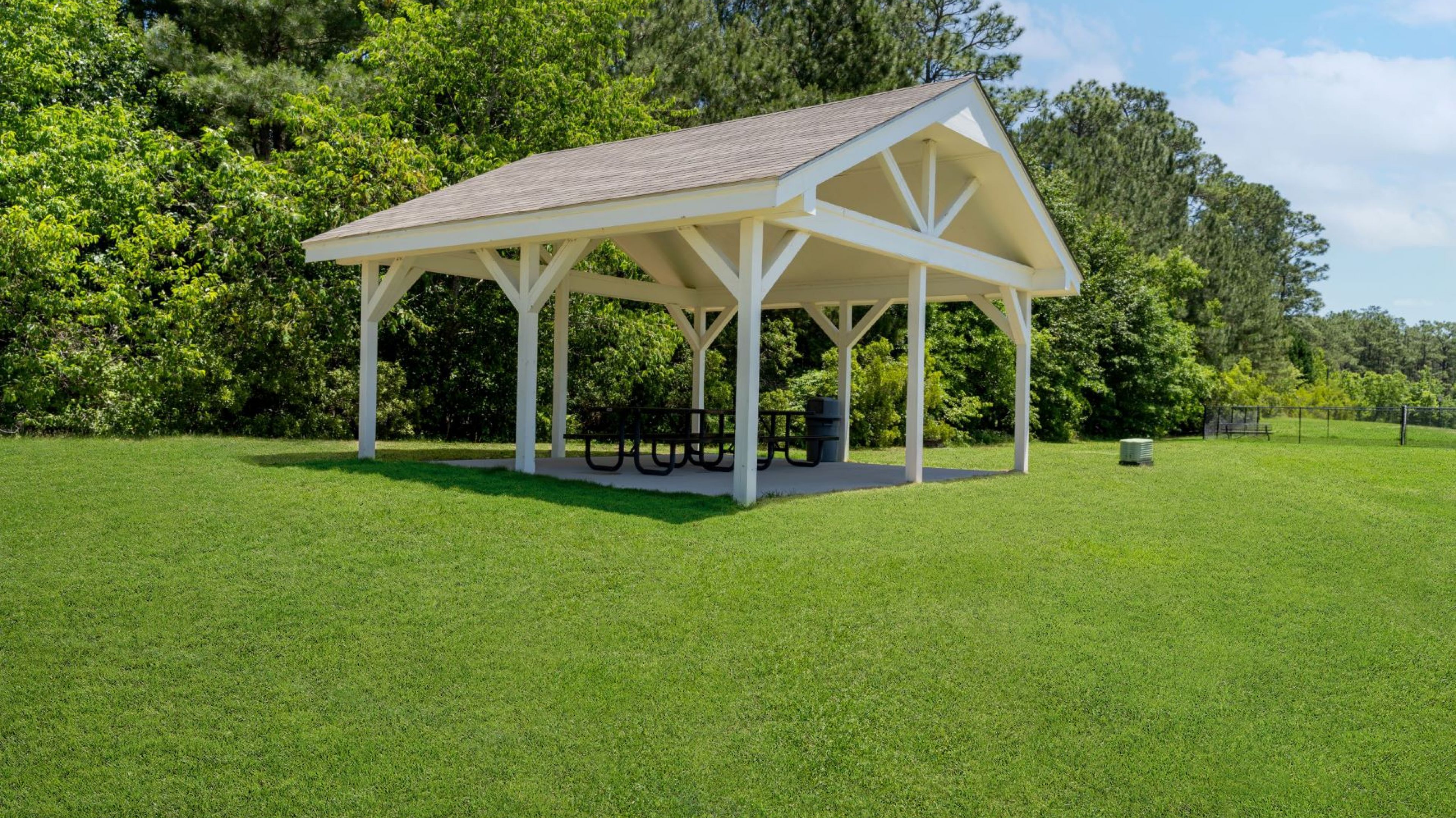 Hawthorne at the Pines spacious picnic pavilion with a white roof set in a green park area, offering a relaxing community space